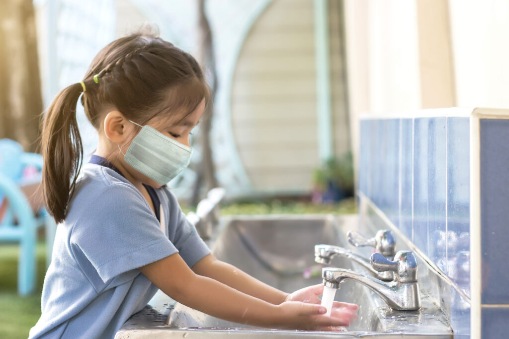 Kid play outdoor with mask when back to school after coronavirus