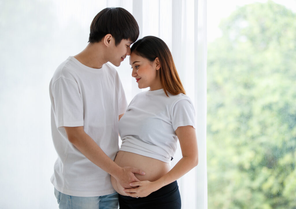 Portrait of a young happy asian couple standing together by the